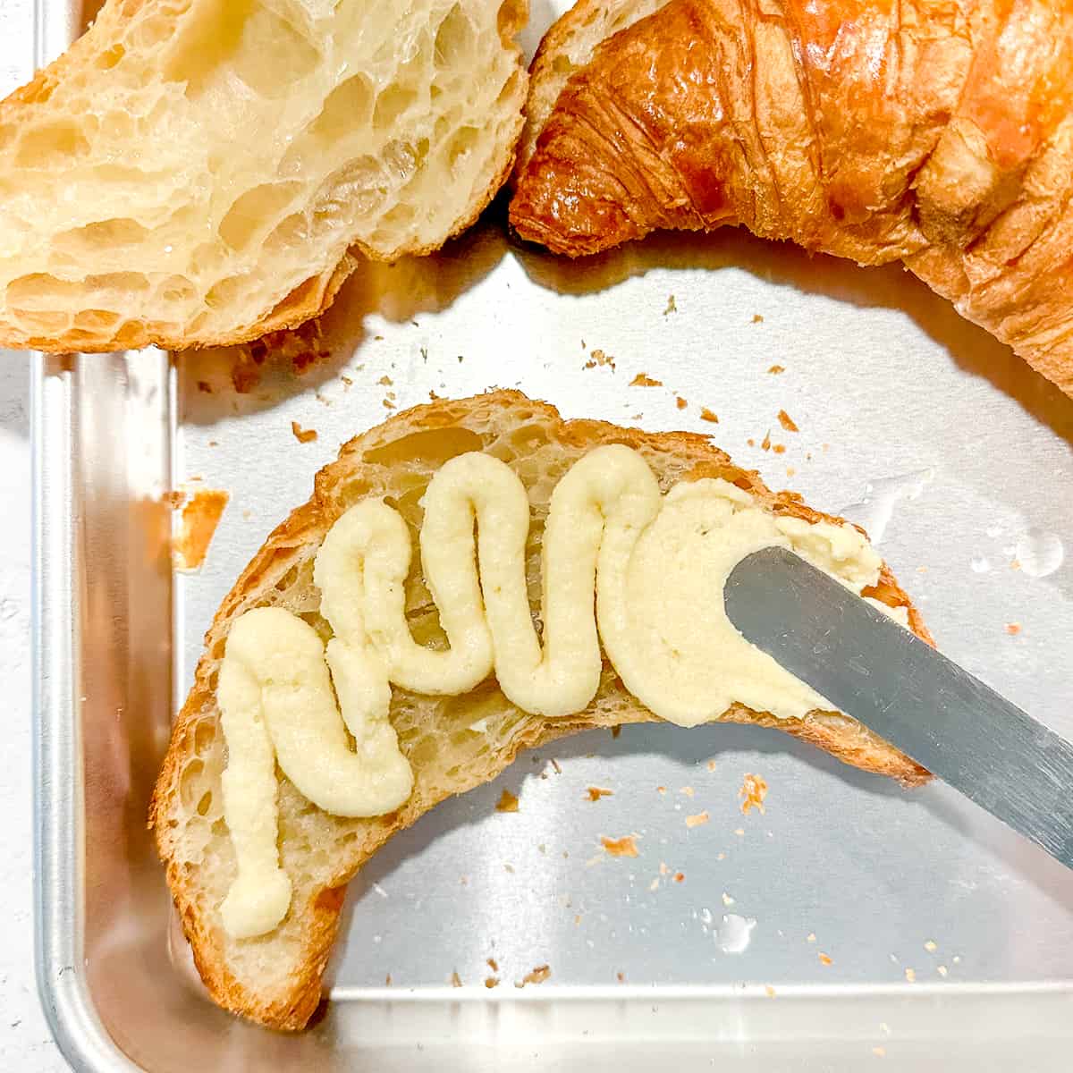spreading frangipane inside of a croissant.