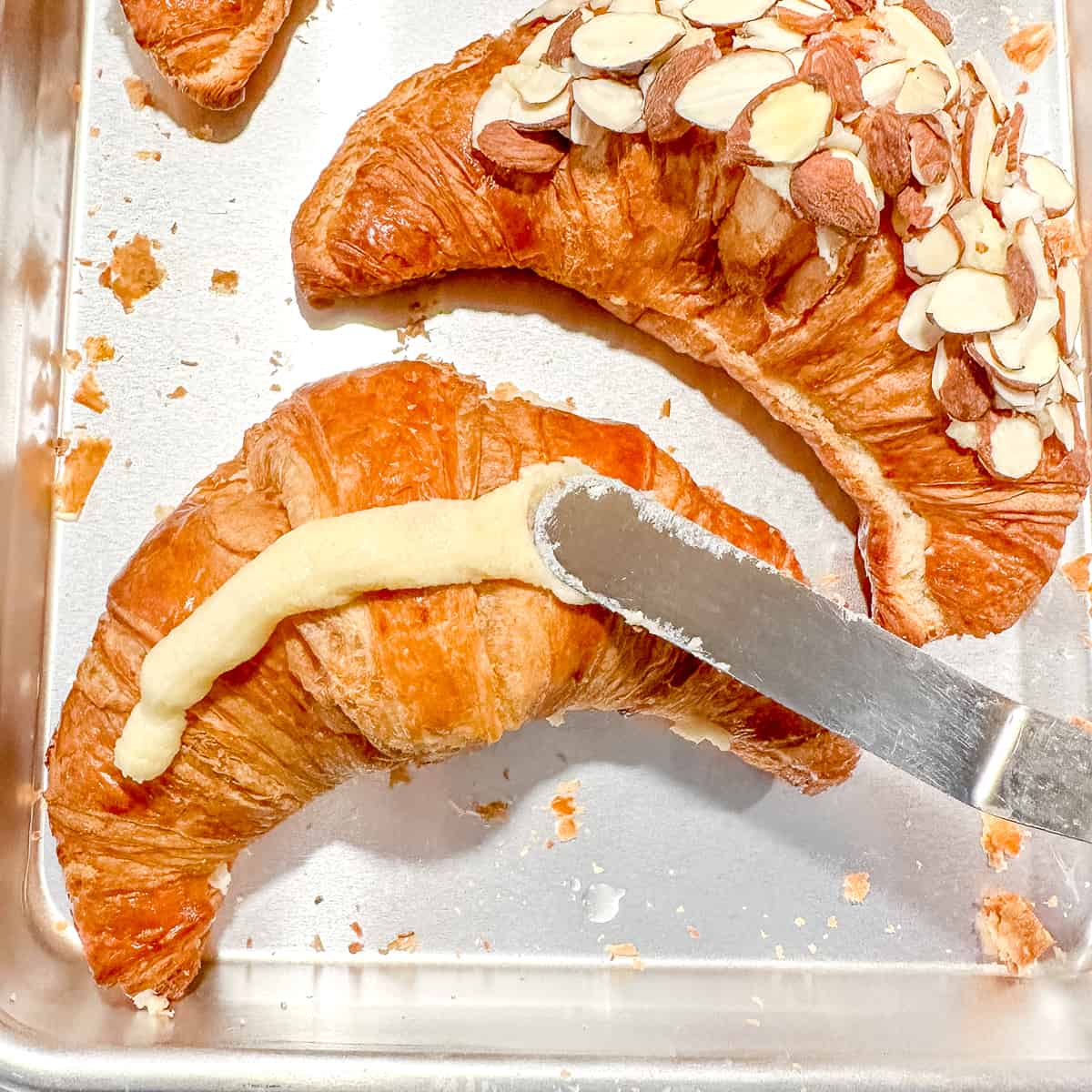 spreading frangipane on top of a croissant.