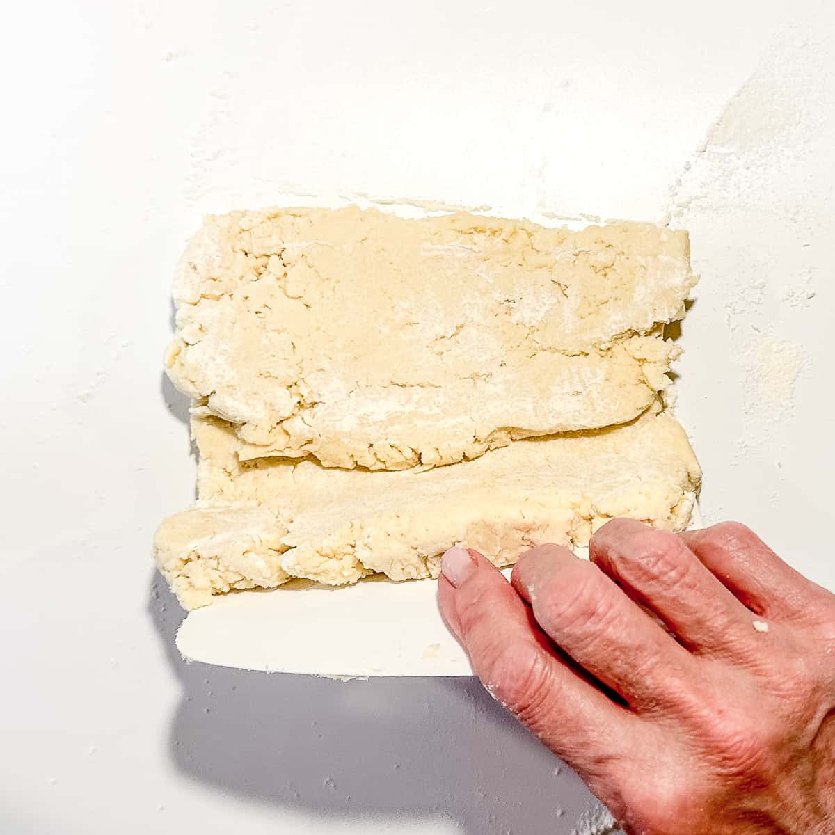 folding biscuit dough with a dough scraper.