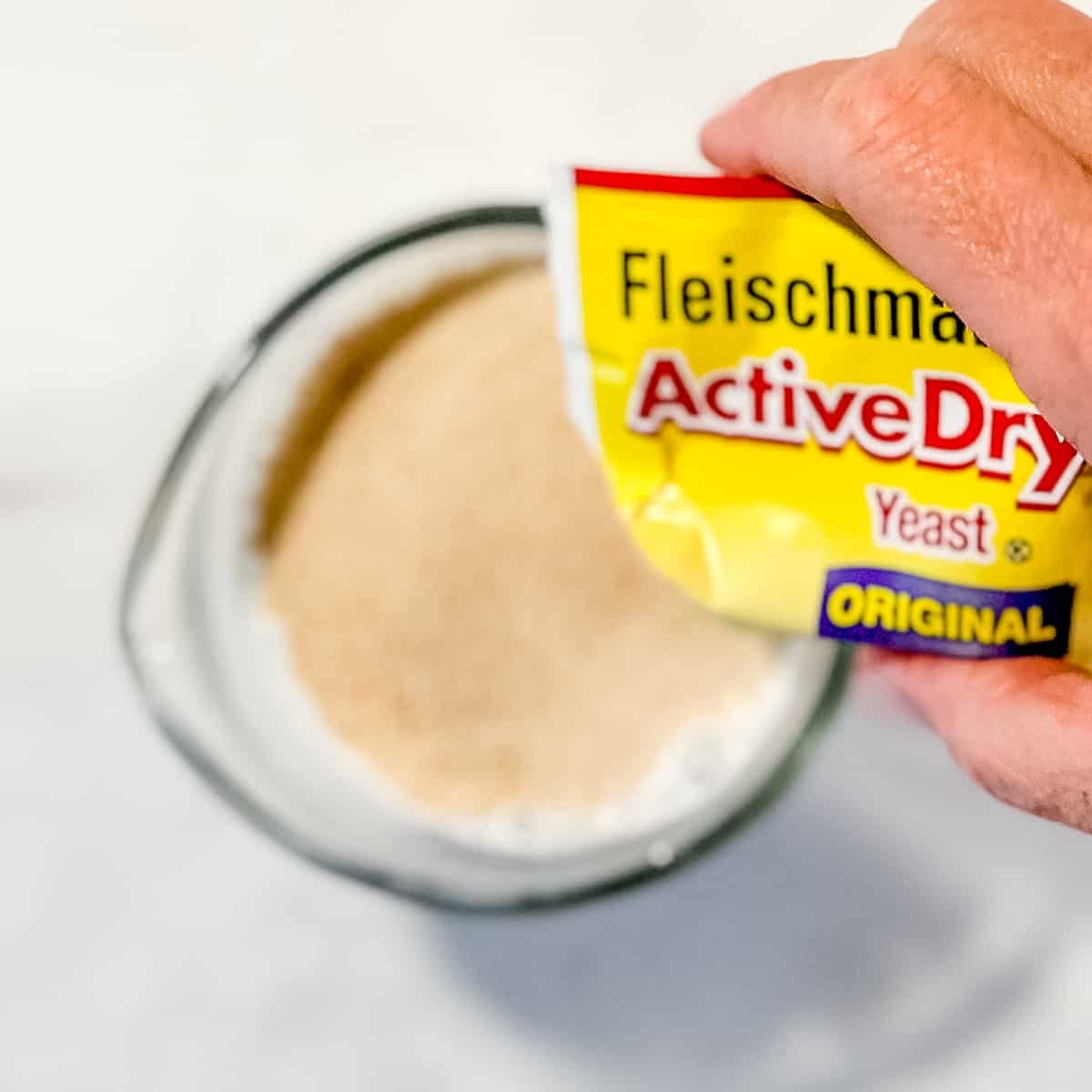 adding active dry yeast to a cup of warm milk.