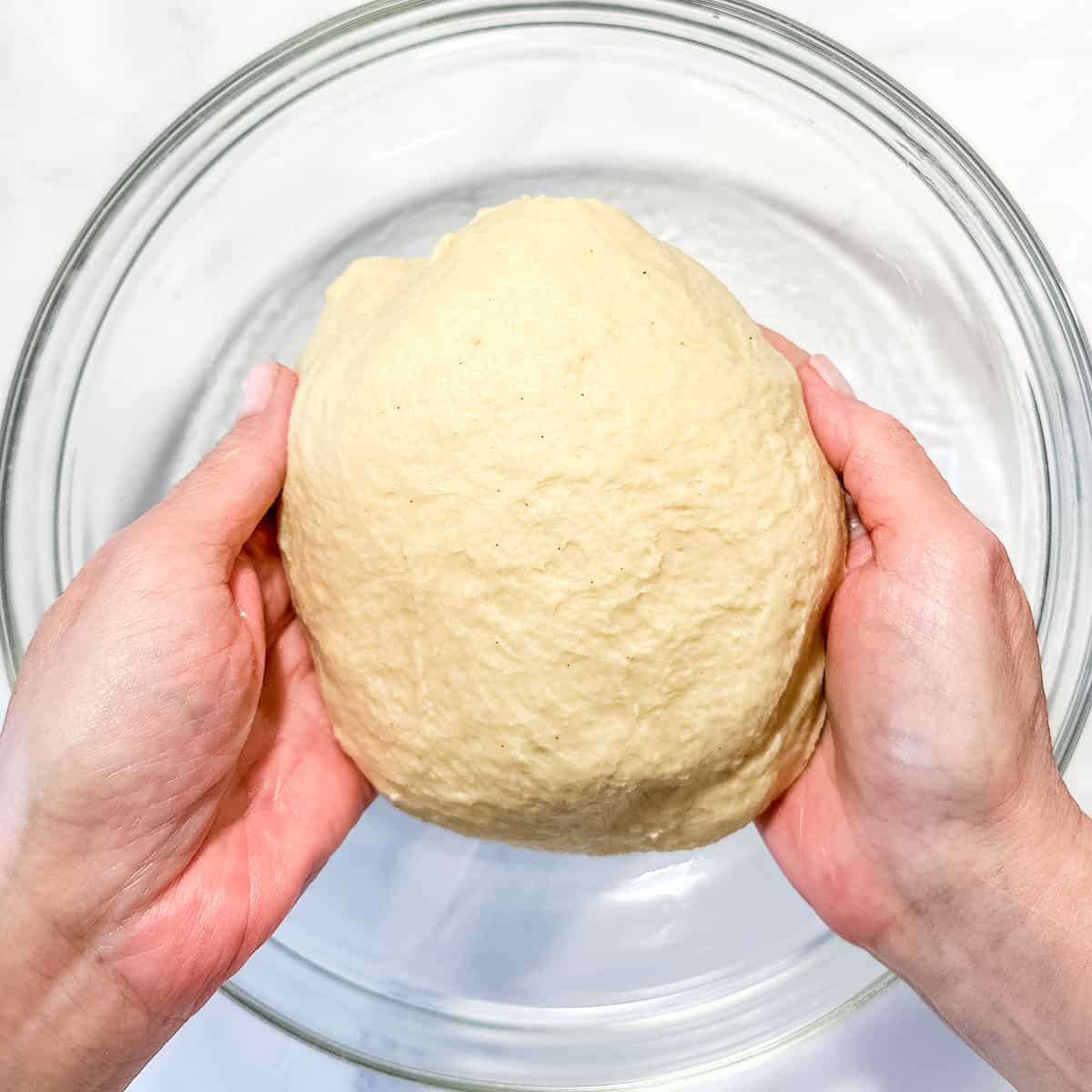 placing brioche dough in an oiled bowl to rise.