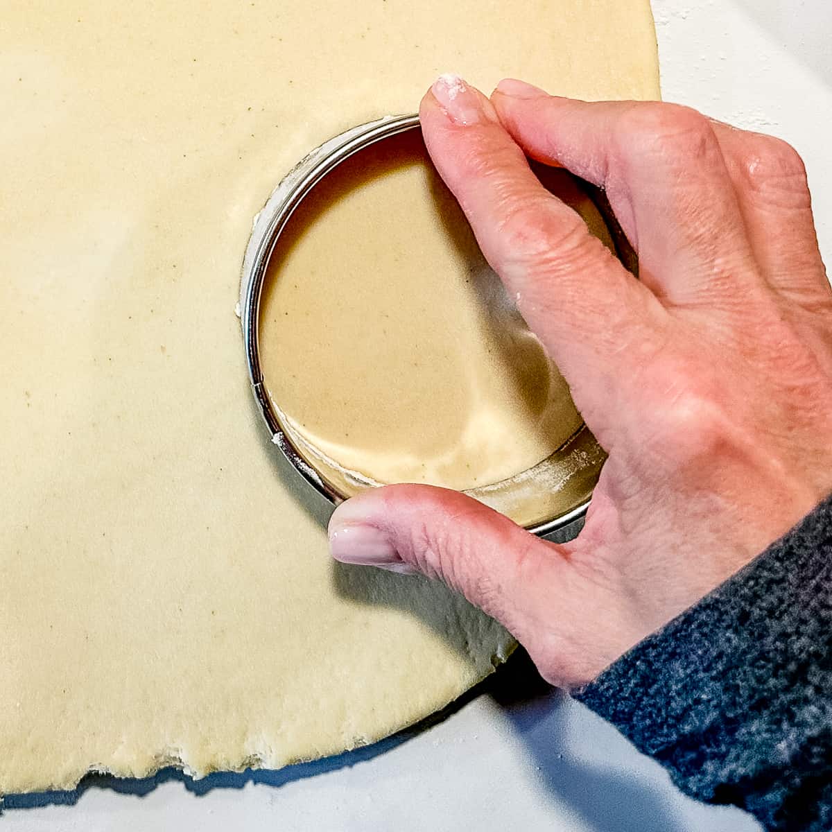 using a large ring cutter to cut out a donut.