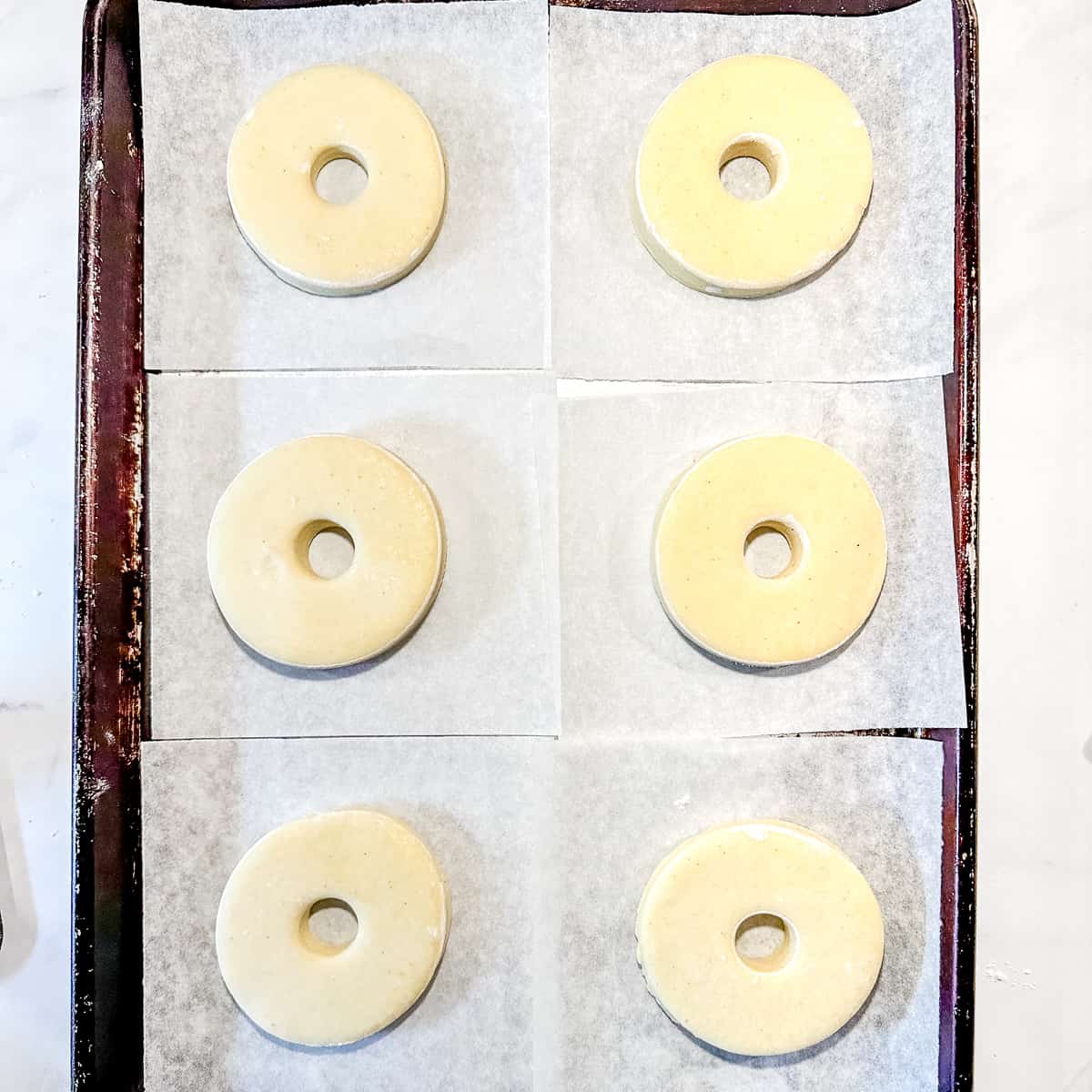 cut donuts on pieces of parchment paper