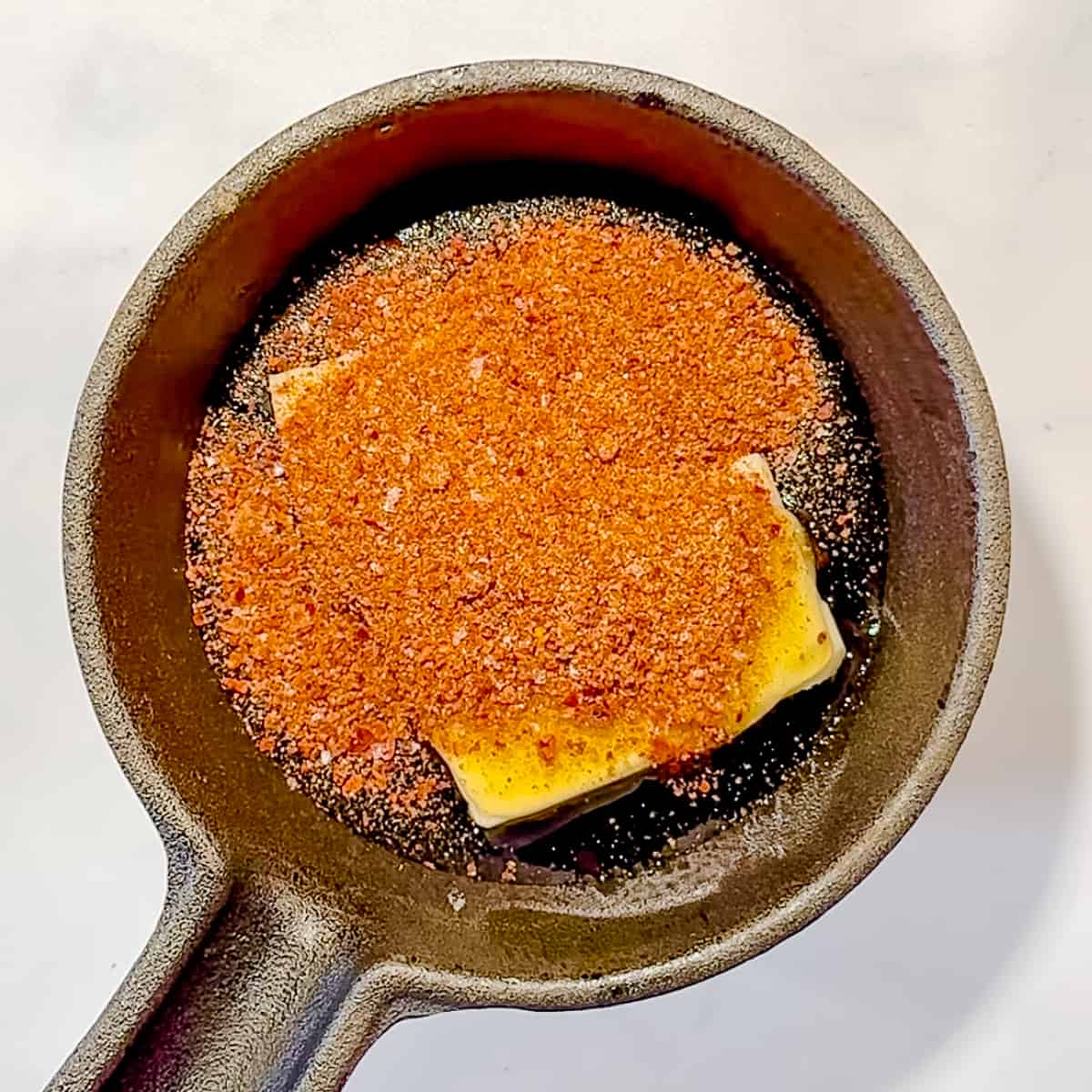 making spicy maple honey butter in a small cast iron skillet.
