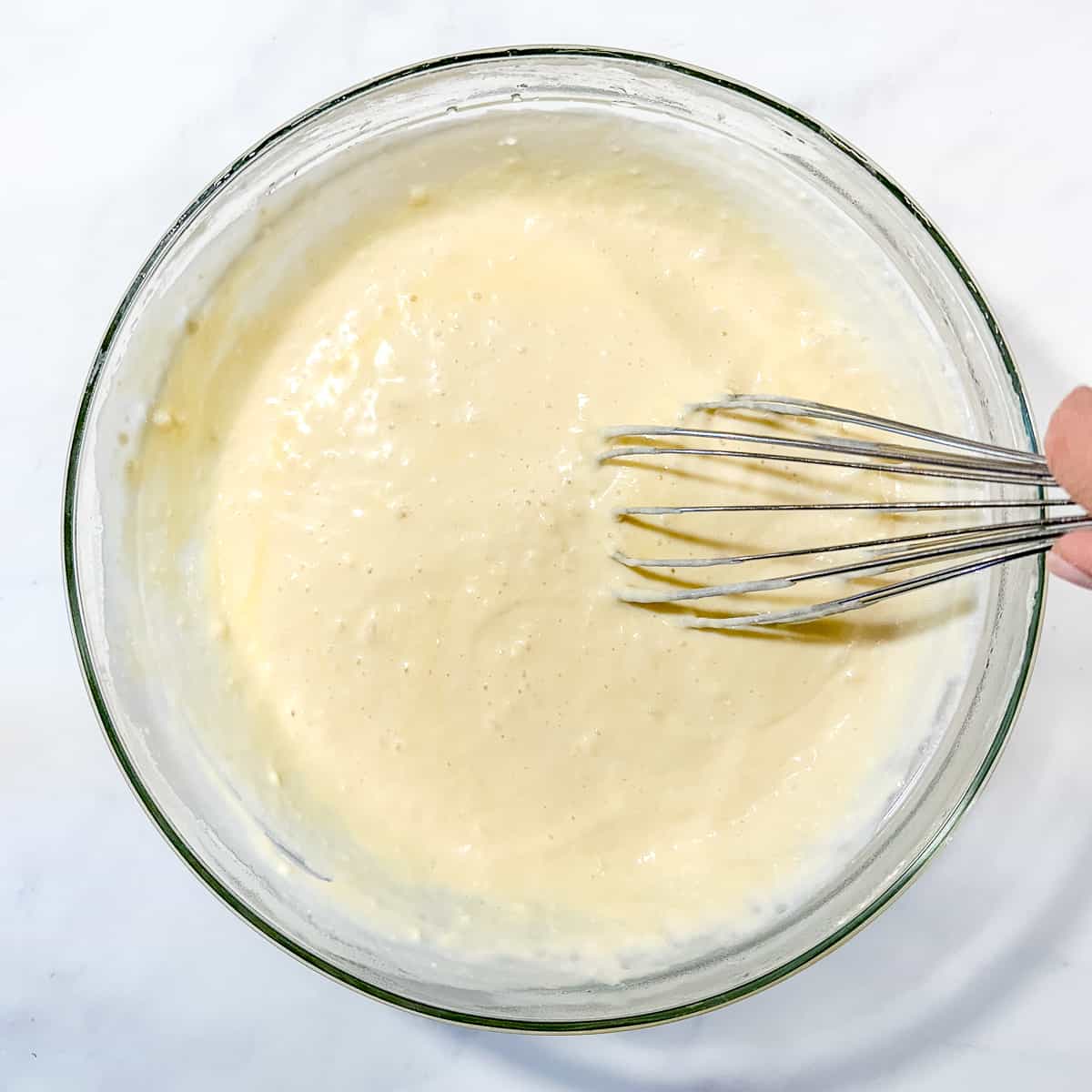 whisking yeast waffle batter.