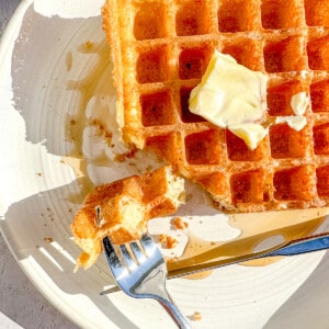 closeup of yeast waffles with a corner cut.