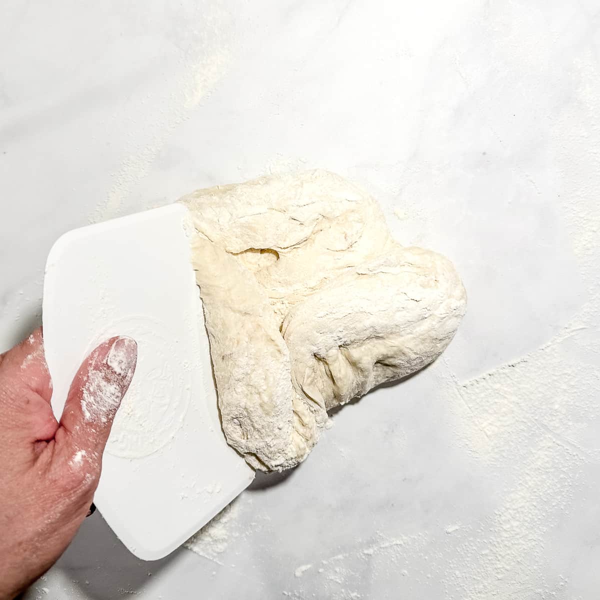 folding edges of dough over themselves to form a large dough ball.