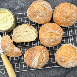 baked crusty rolls with a knife and butter.