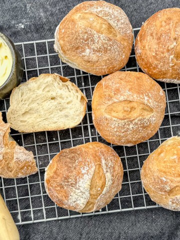 baked crusty rolls with a knife and butter.