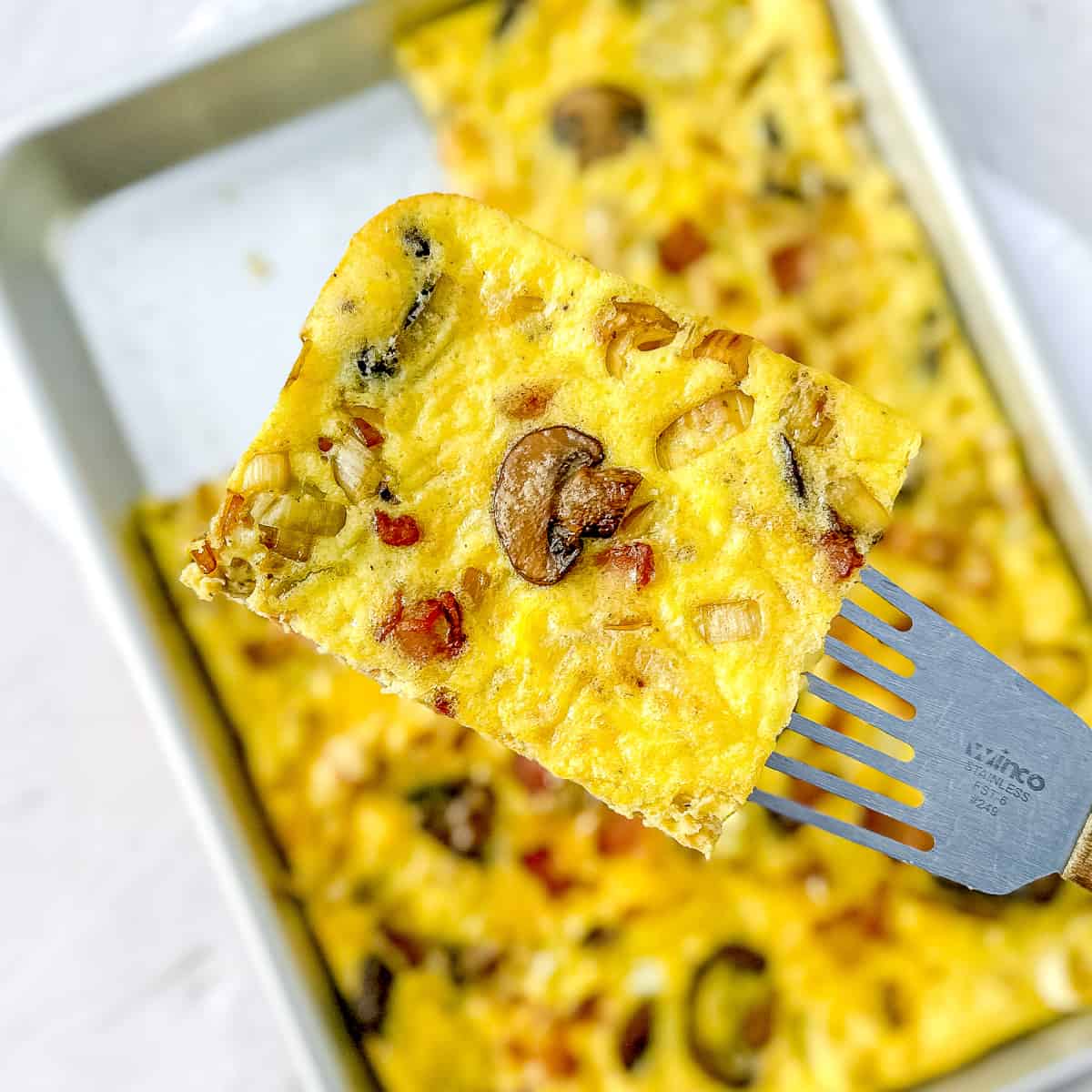 a slice of sheet pan frittata on a spatula.