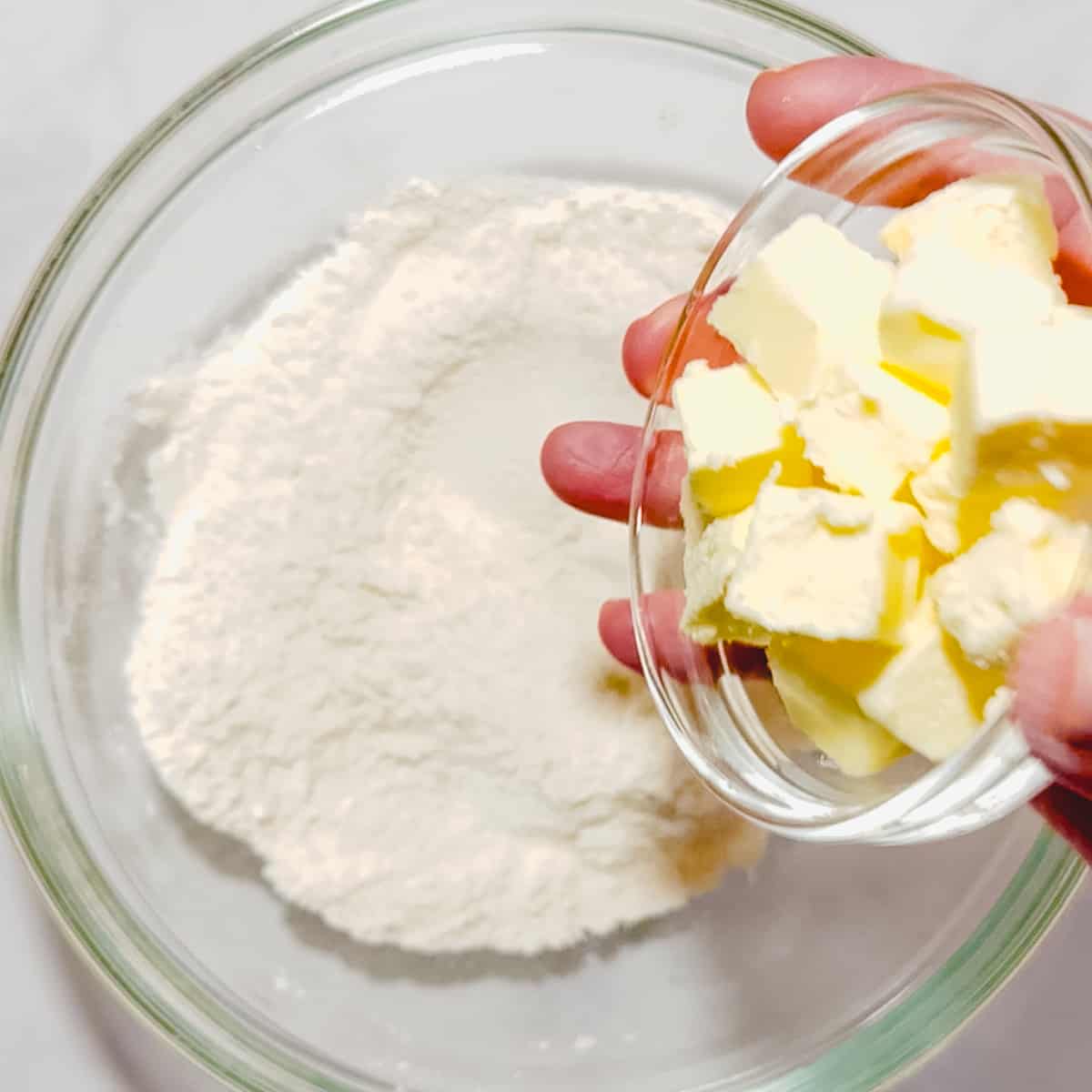 adding butter to dry ingredients for biscuits.