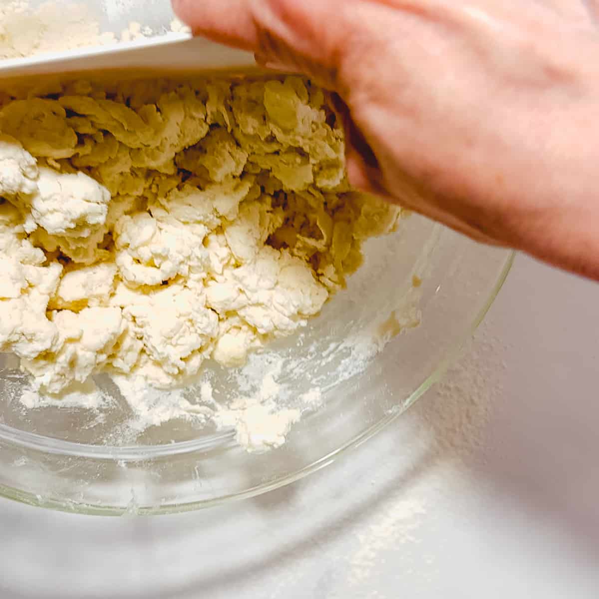 dumping biscuit dough out of bowl.