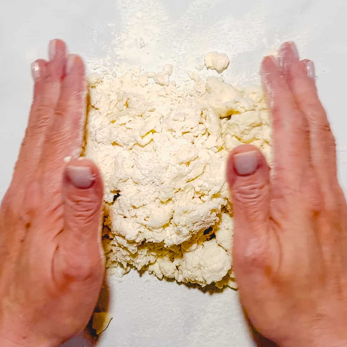 gathering biscuit dough together on counter.