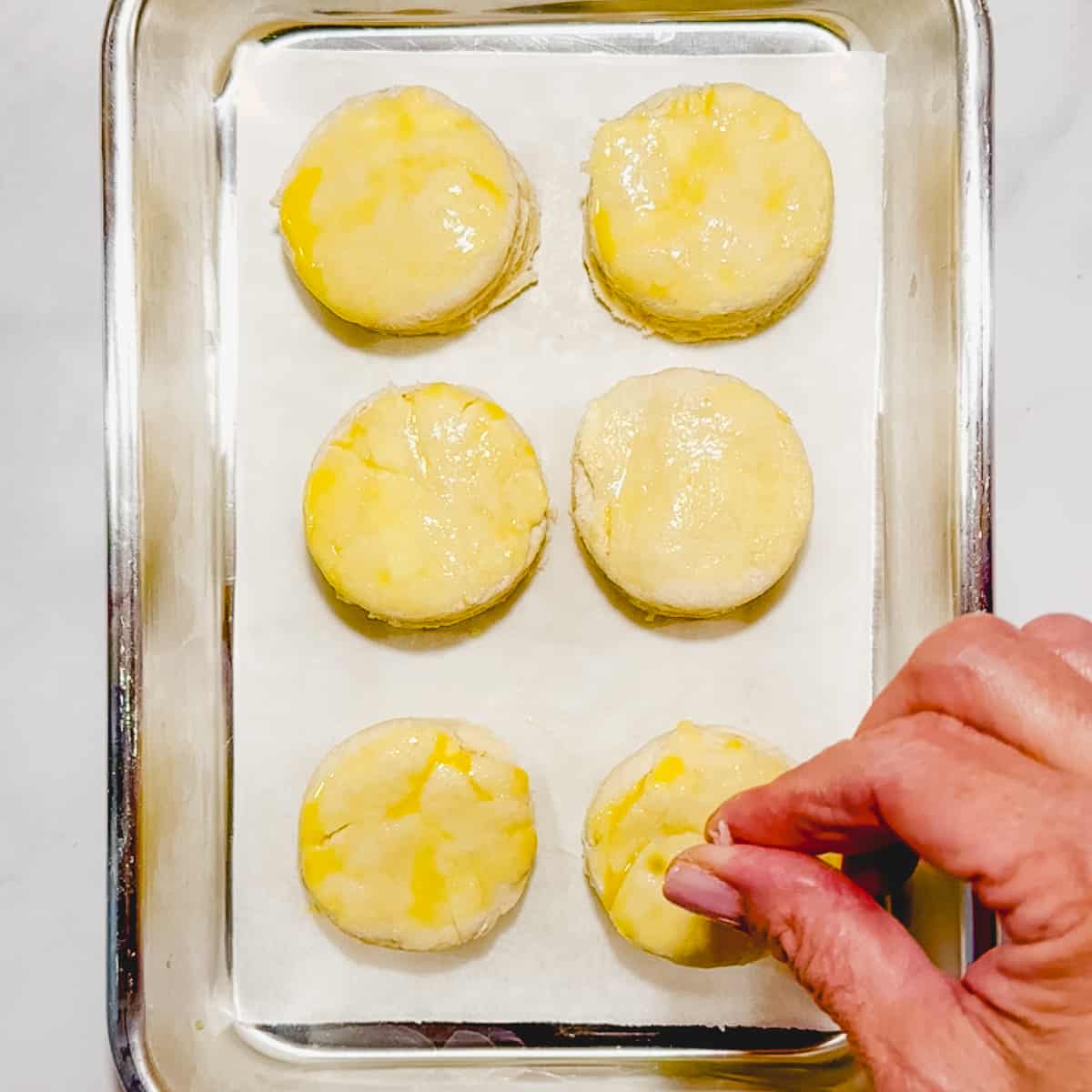 sprinkling flaky salt on raw biscuits.