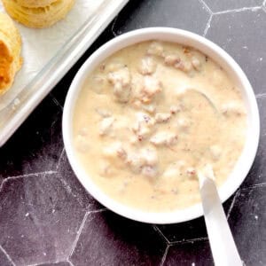 Sausage gravy in a bowl with a silver ladle.