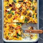 Frittata on a sheet pan with a spatula.