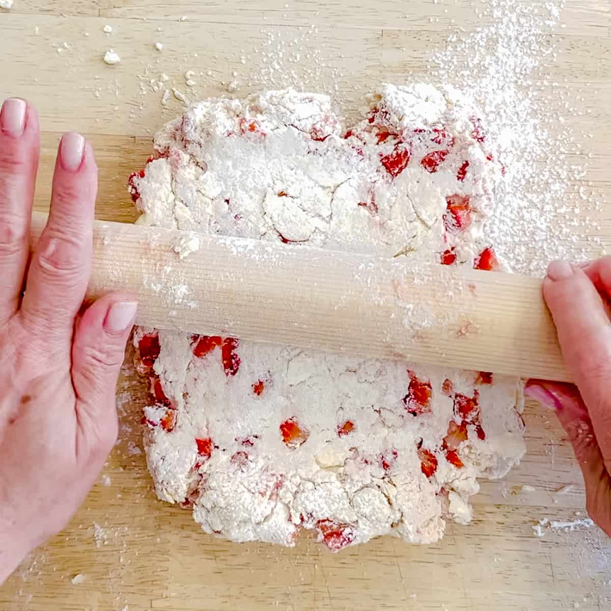 rolling out strawberry biscuit dough.