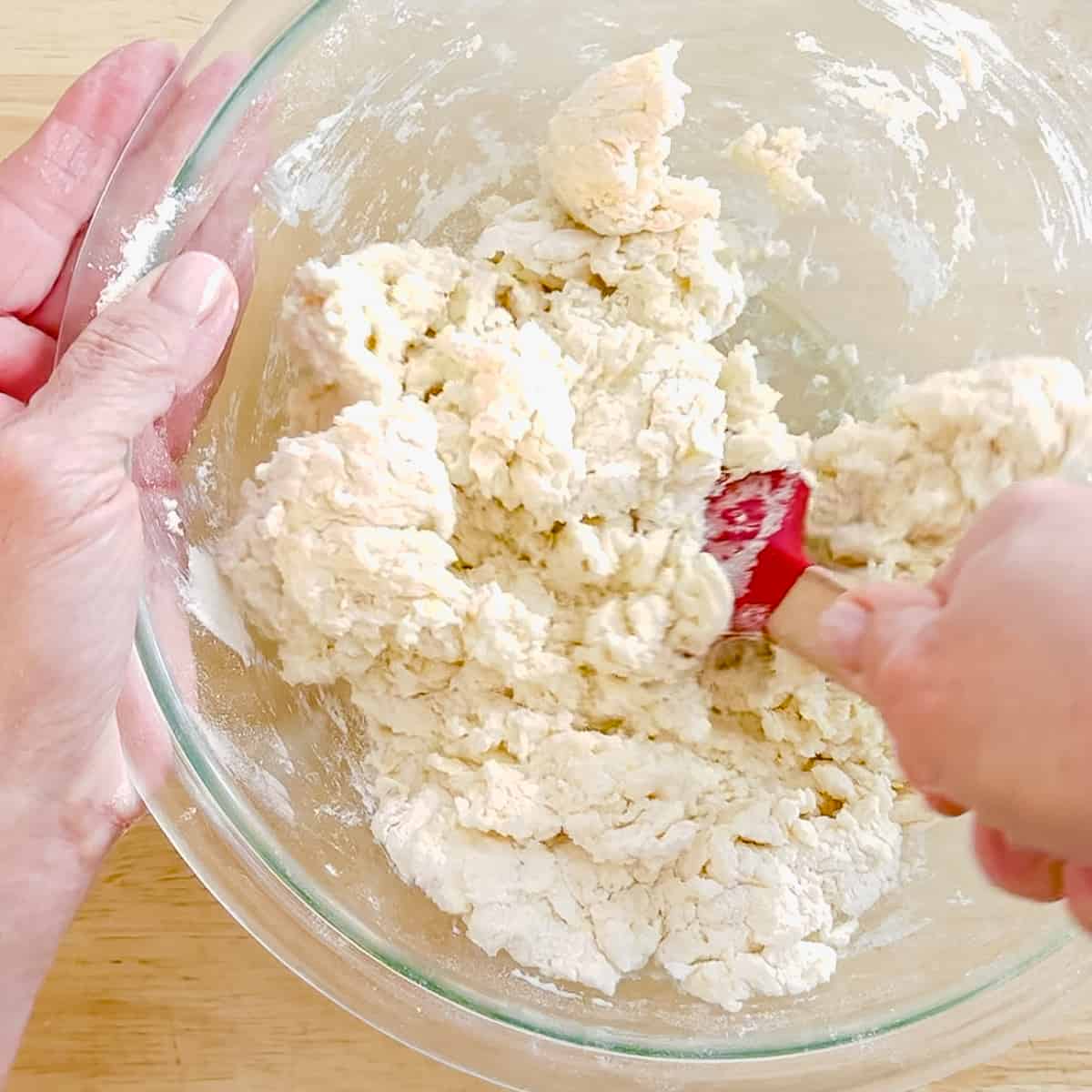 using a spatula to mix biscuit dough.