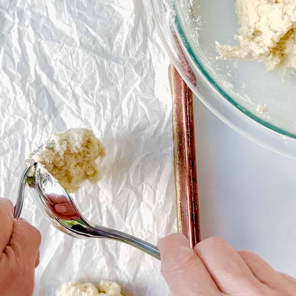 using 2 spoons to portion biscuit dough.