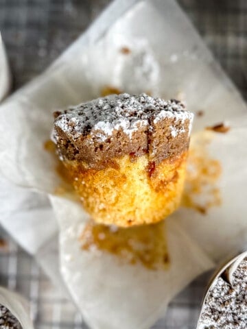 side view of an unwrapped crumb cake muffin.