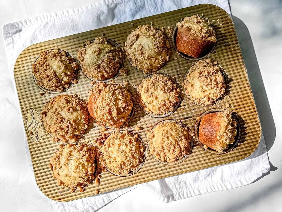 baked banana nut muffins with streusel in a muffin pan.