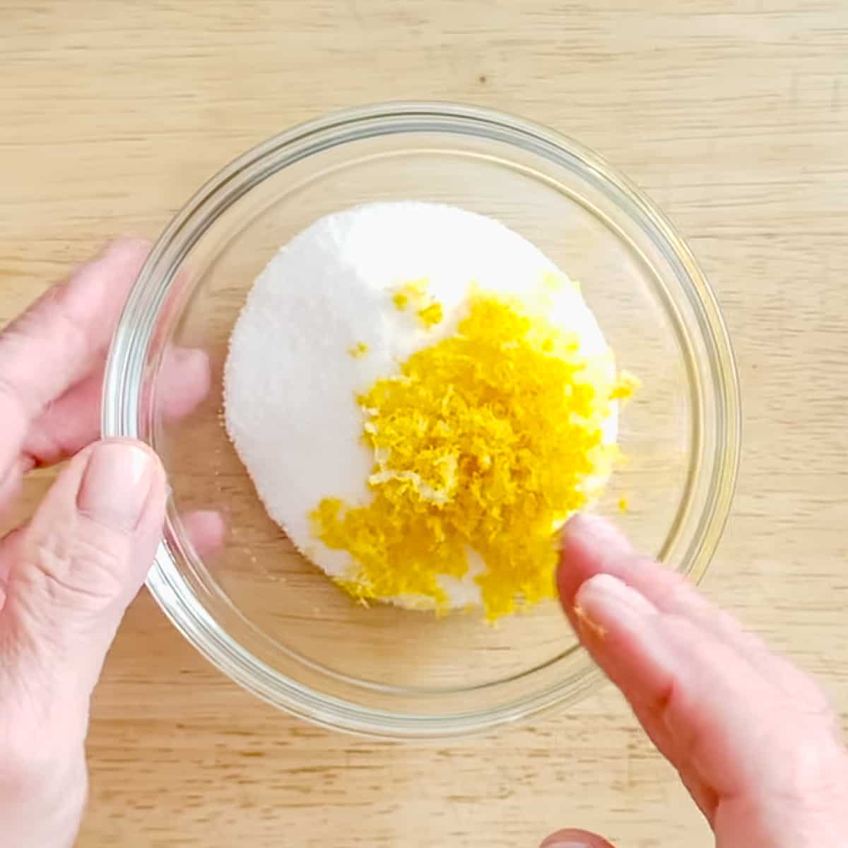 adding lemon zest to granulated sugar.