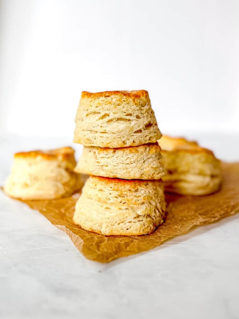 A stack of buttermilk biscuits on parchment paper.