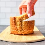 Hand lifting a slice of banana bread from a stack.