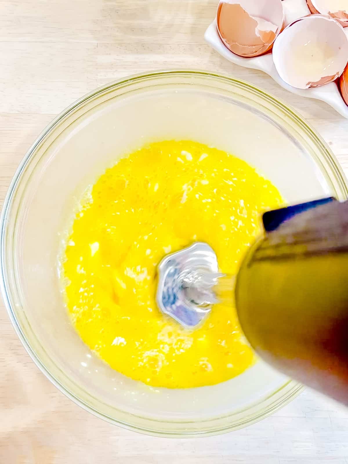 Mixing ricotta and raw eggs together with an immersion blender.