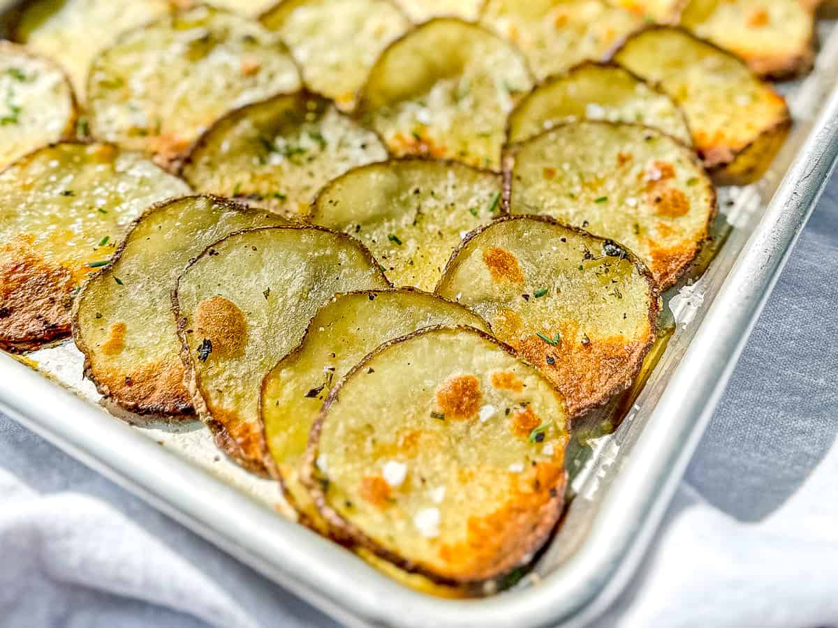 Sheet pan filled with crispy roasted potato slices.