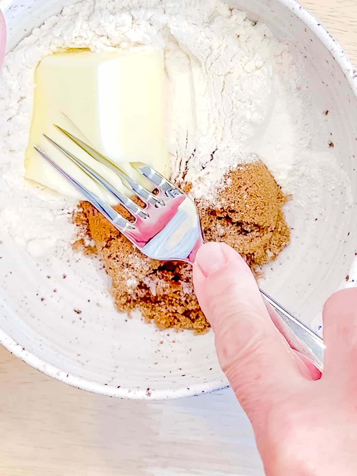 Using a fork to cut butter into ingredients for streusel.