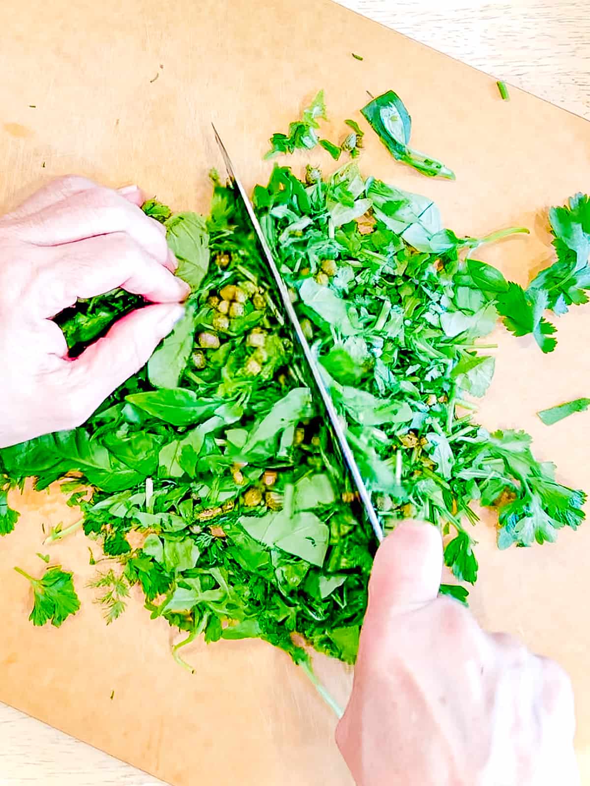 Chopping fresh herbs ands capers.