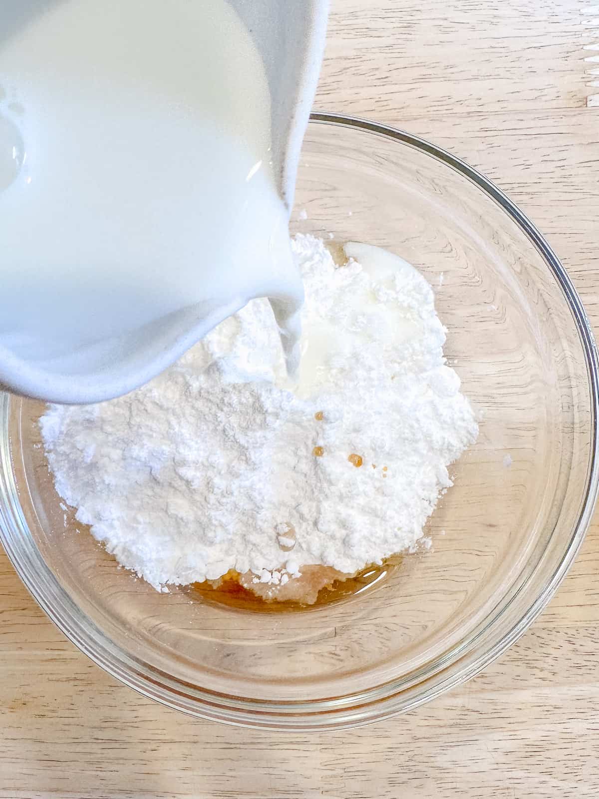 Pouring milk into powdered sugar to make glaze.