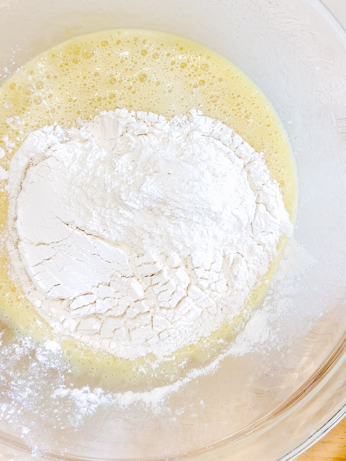 Adding flour to wet ingredients for old fashioned buttermilk donuts.