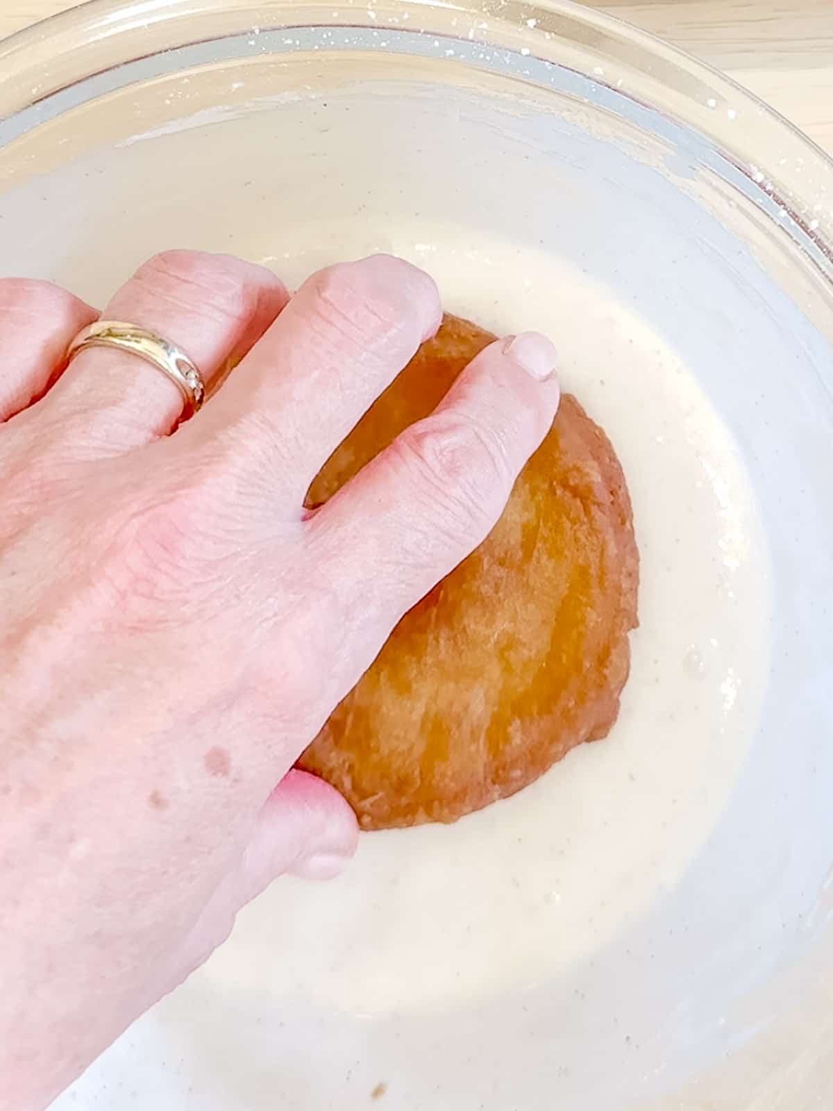 Dunking a donut in glaze.