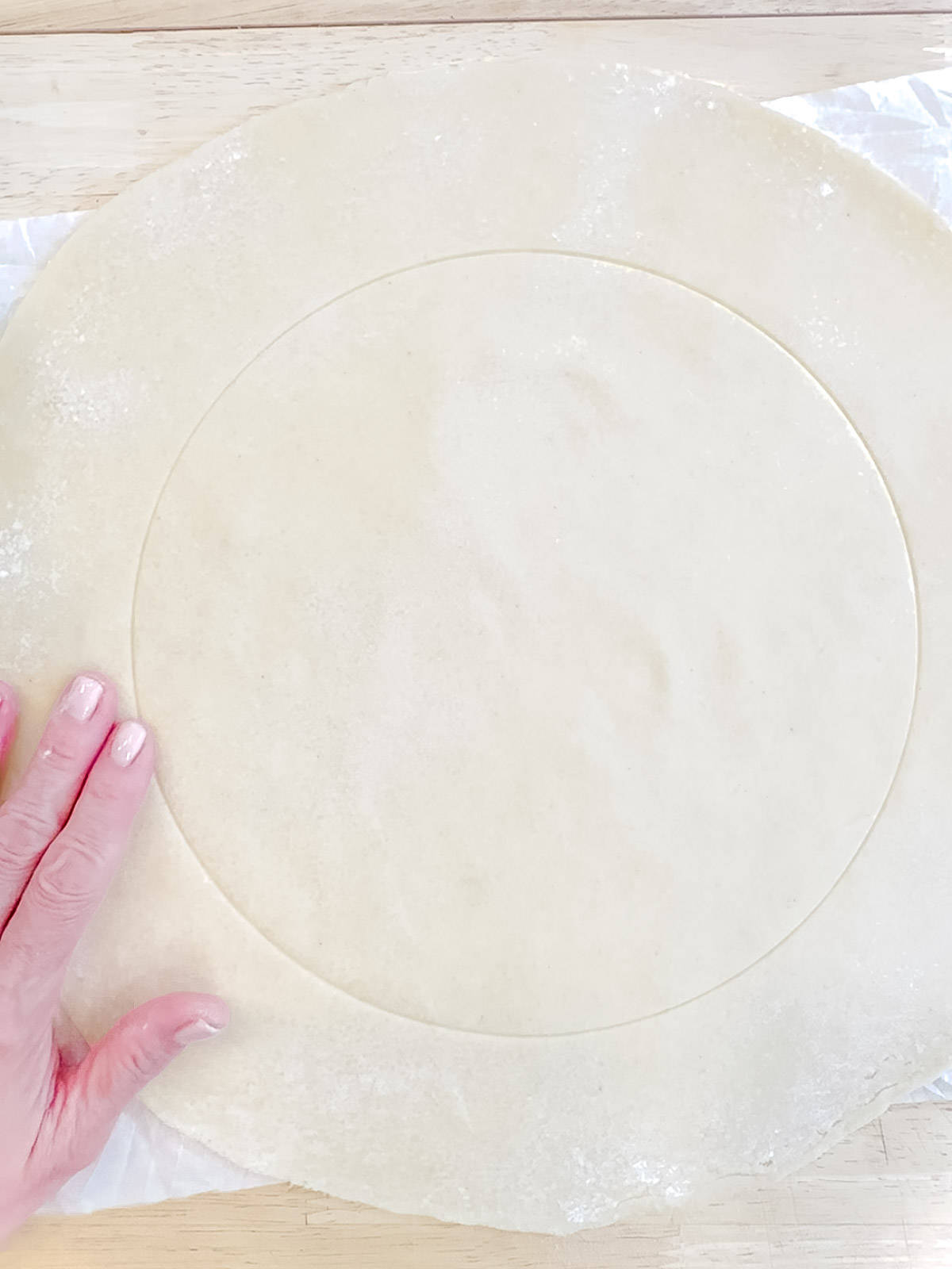 Showing a marked circle for containing fillings on galette crust.