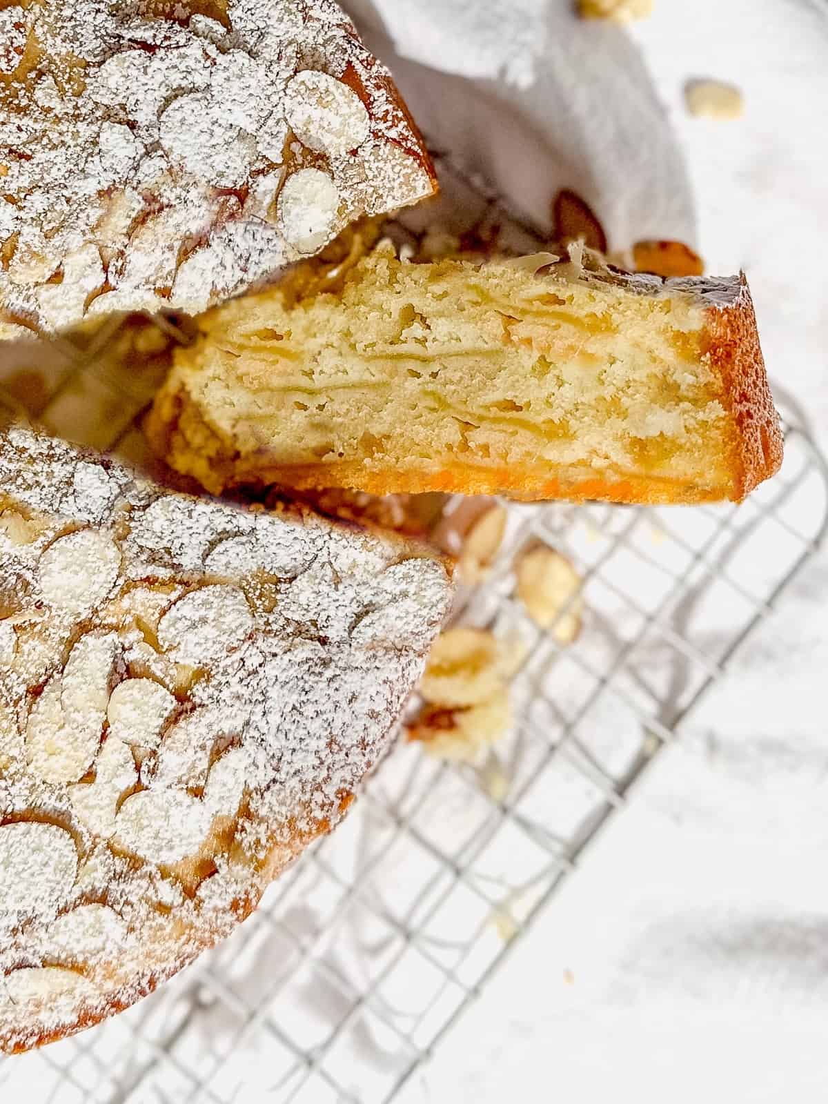 Side view of a slice of apple cake with almonds.
