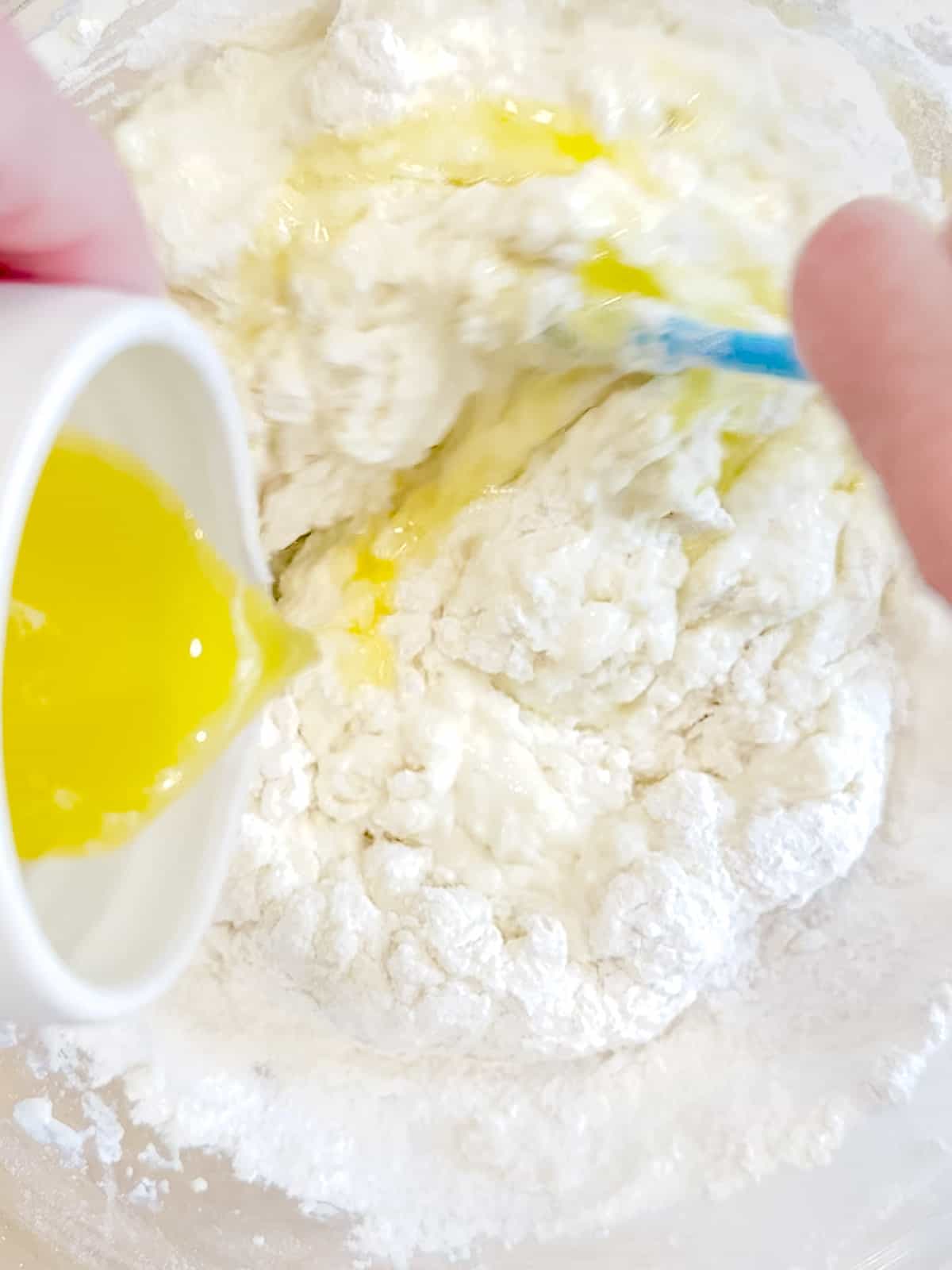 Adding melted butter to yogurt pancake batter.