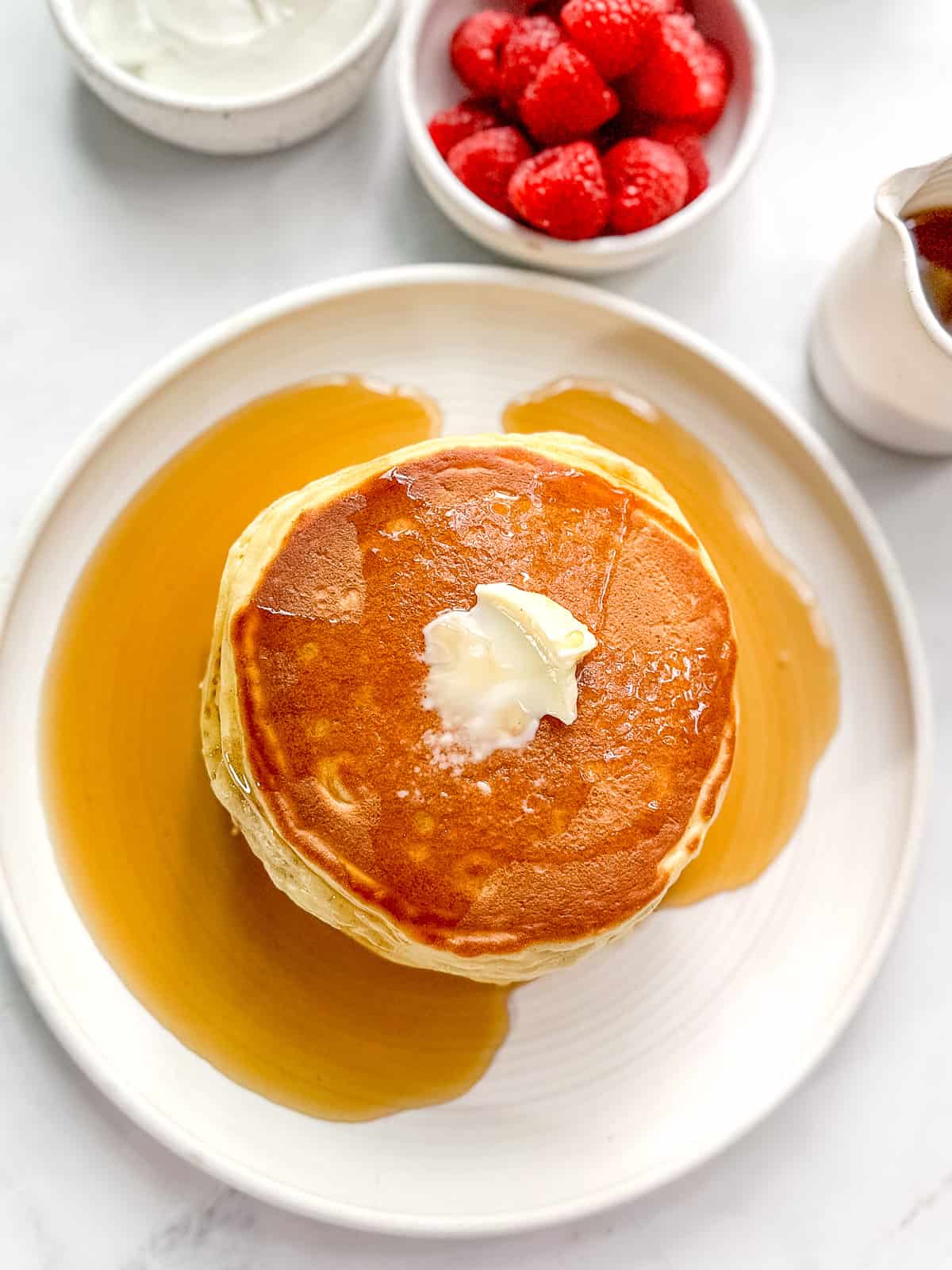 A stack of yogurt pancakes with syrup.