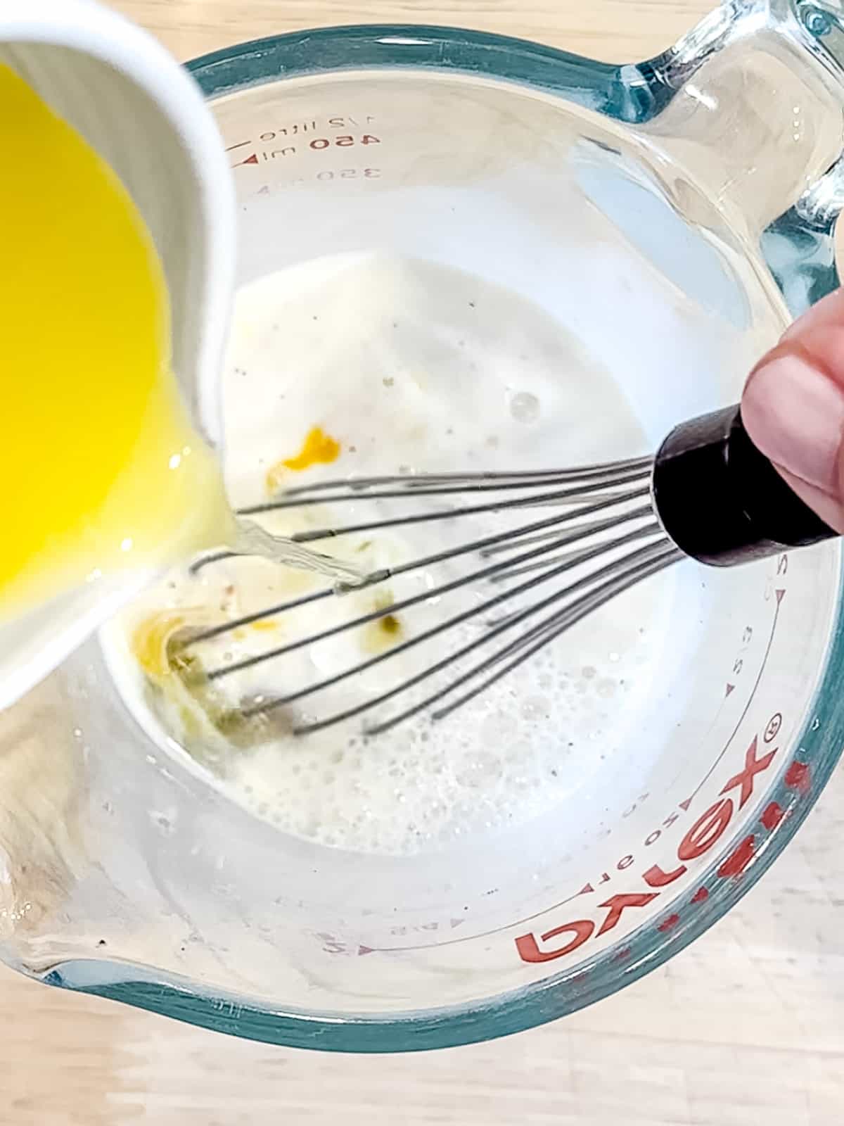 Whisking butter into room temperature milk.