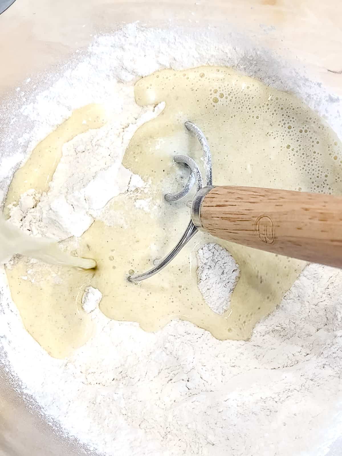 Mixing wet and dry ingredients to make cinnamon roll dough.