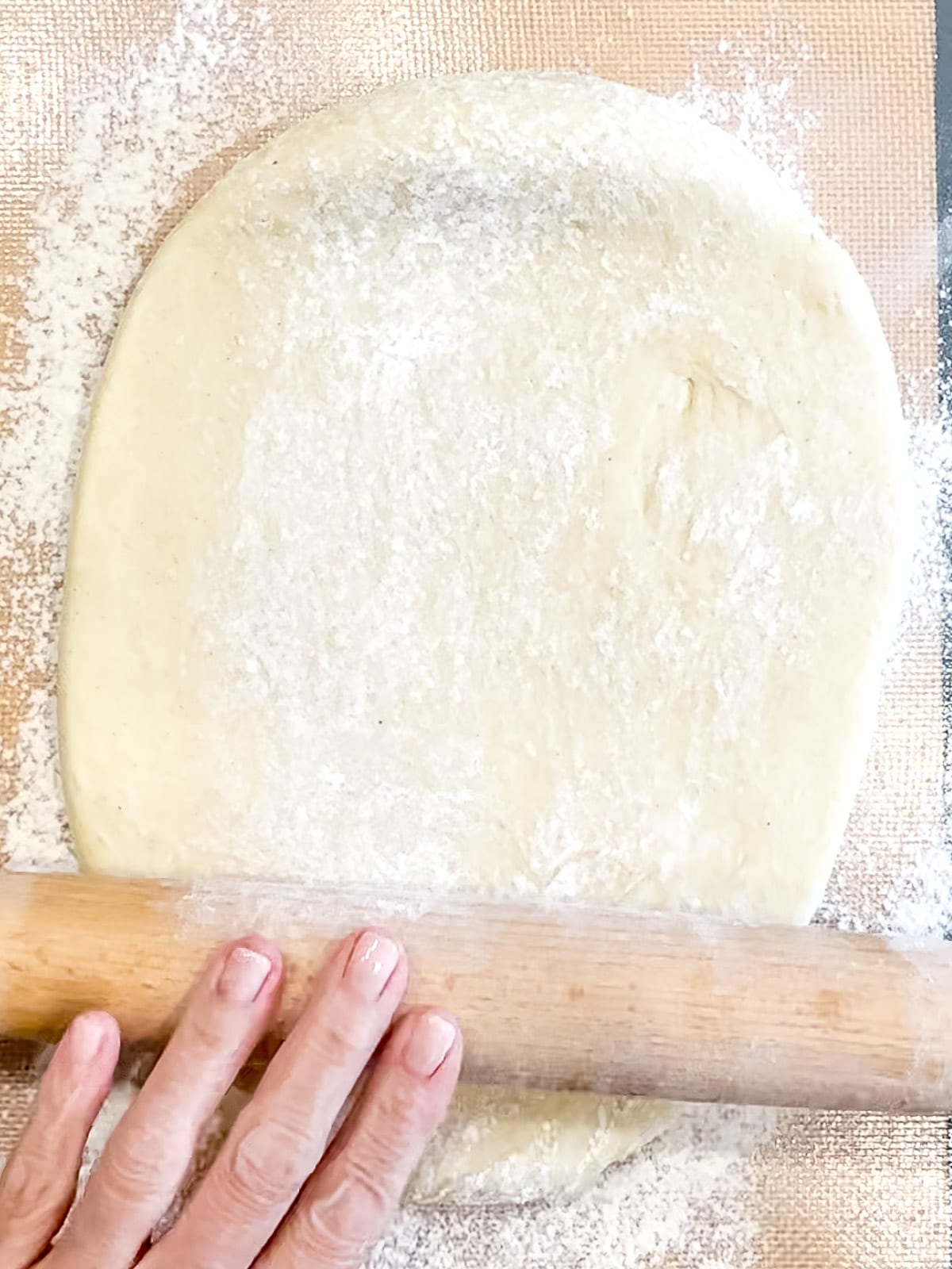 Rolling out dough to make cinnamon rolls.