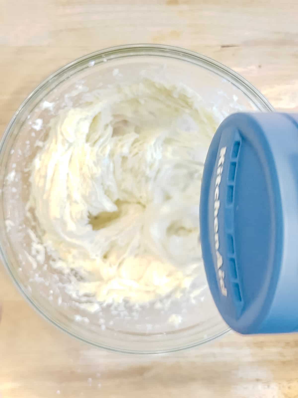 Using a hand mixer to make cream cheese frosting.