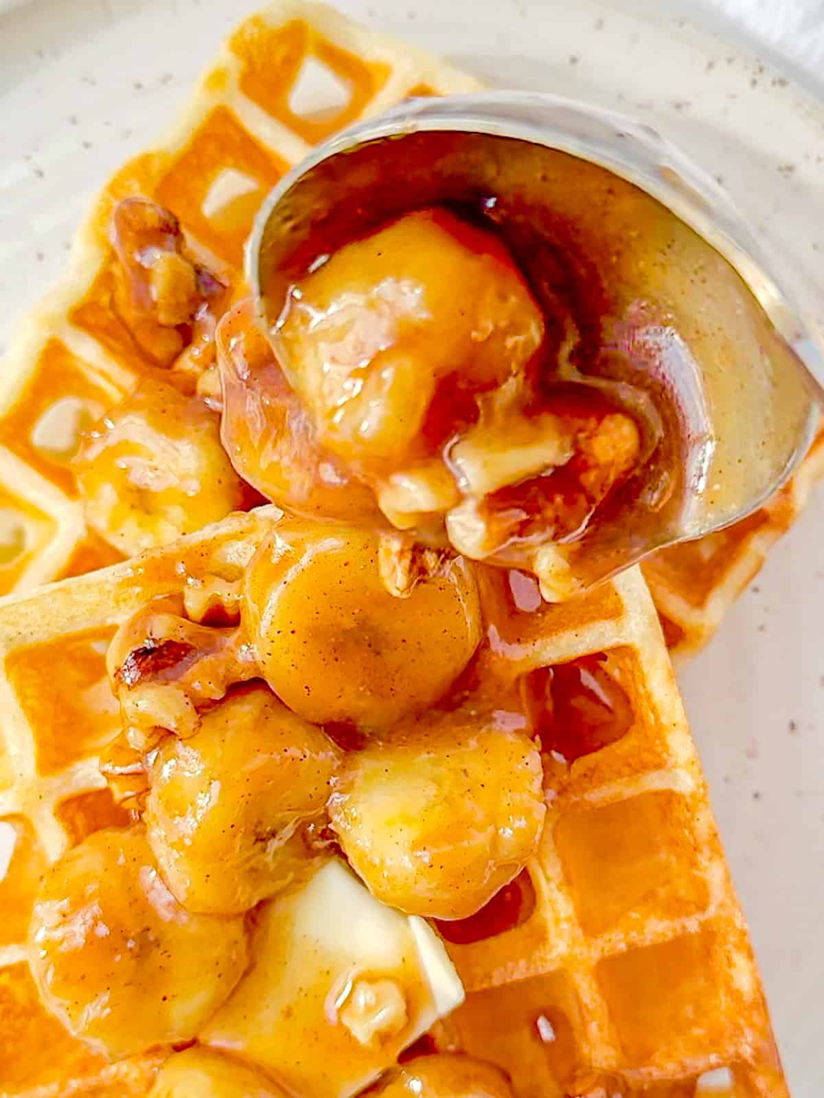 Pouring bananas foster sauce on buttermilk waffles.