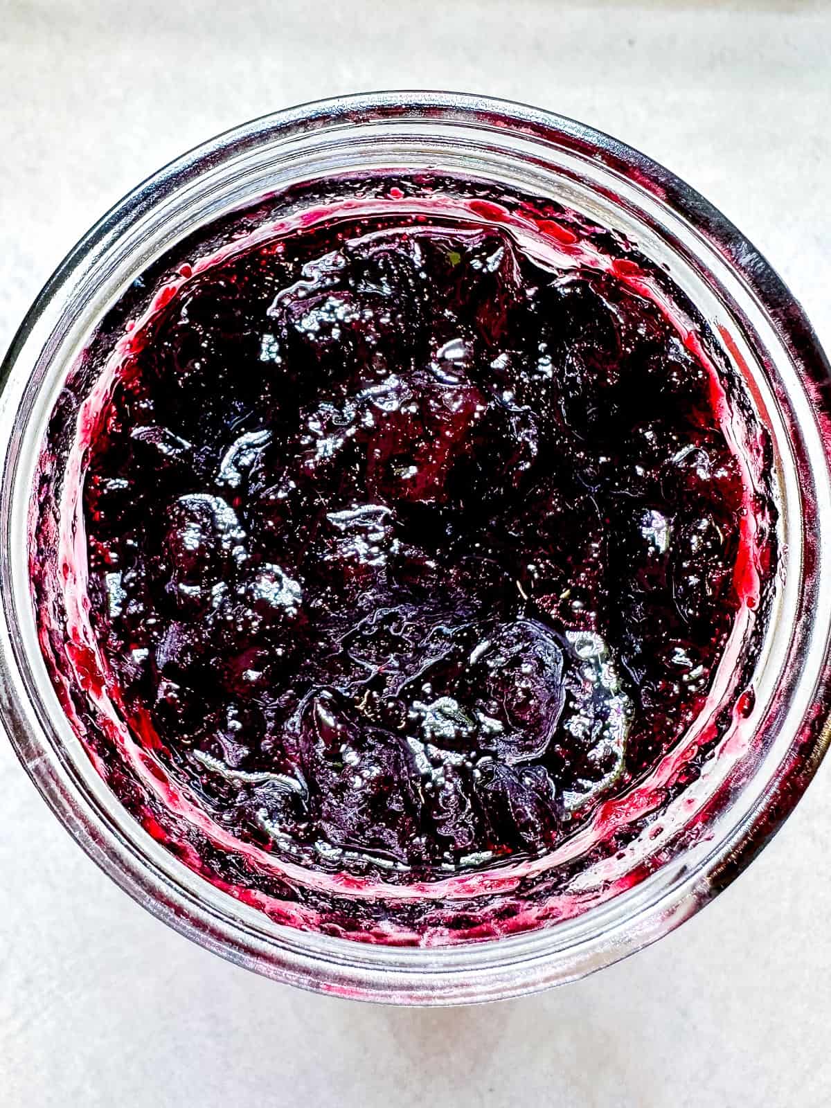 A mason jar full of blueberry orange jam.