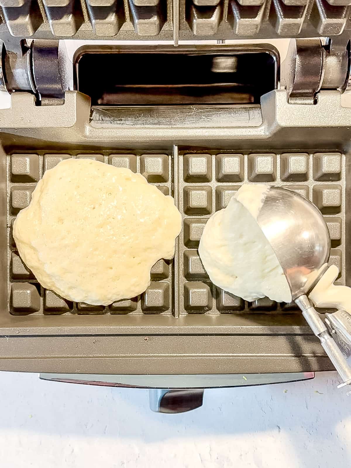 Scooping waffle batter into waffle maker.