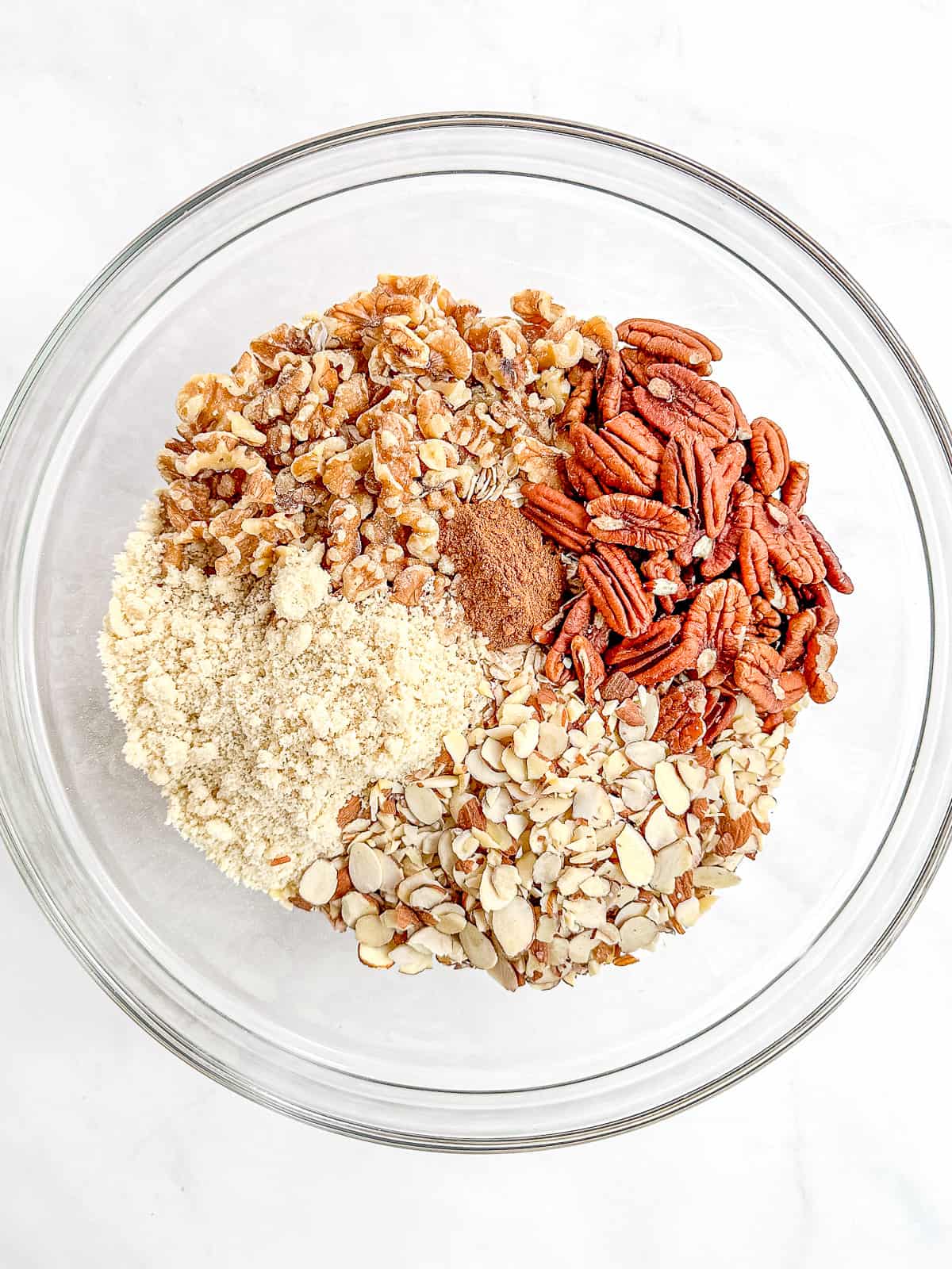 Ingredients to make granola in glass bowl.