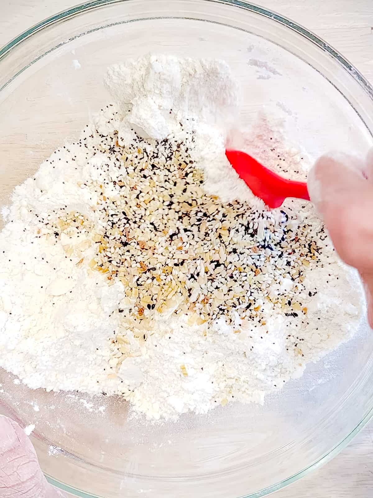 Tossing everything bagel seasoning into flour and butter mixture for biscuits.