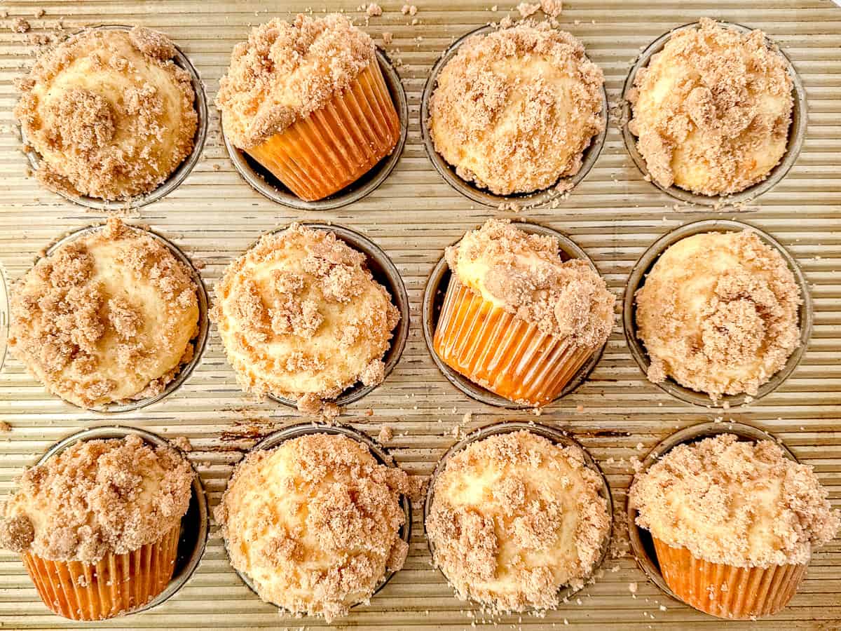 Sour cream coffee cake muffins in a muffin pan.