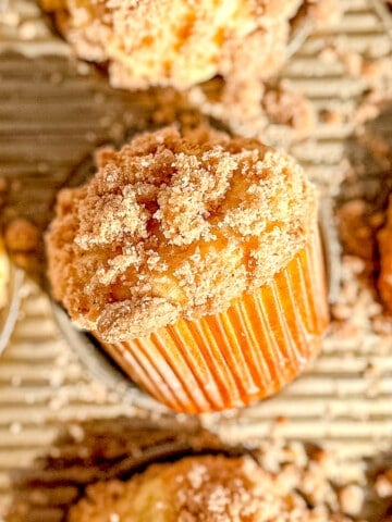 Sour cream coffee cake muffins in a muffin pan.